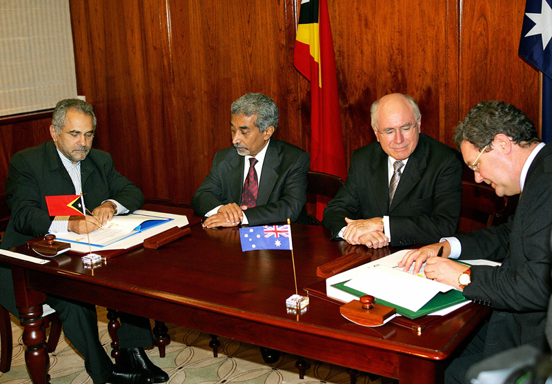 Australian Prime Minister John Howard and Timor-Leste Prime Minister Mari Alkatiri watch as their respective foreign ministers, Jose Ramos-Horta and Alexander Downer, sign the CMATS in Sydney, January 12, 2006. GREG WOOD/AFP/Getty Images.