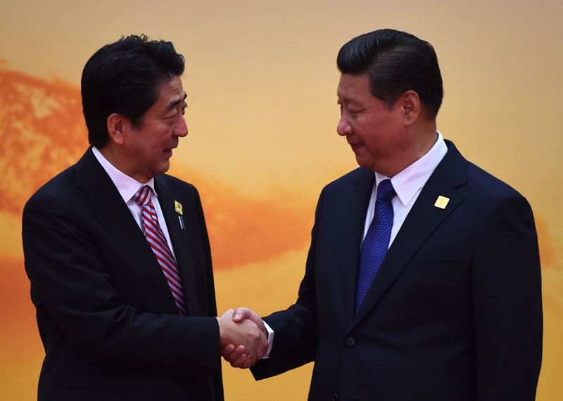 Japan's Prime Minister Shinzo Abe shakes hands with China's President Xi Jinping at the Asia-Pacific Economic Cooperation (APEC) leaders meeting at Yanqi Lake, north of Beijing, on November 11, 2014. GREG BAKER/AFP/Getty Images.