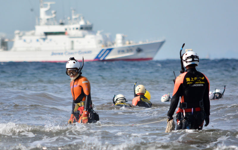 A Japanese Coast Guard marine rescue unit searches for typhoon victims off Oshima island, 120 km south of Tokyo on October 18, 2013. KAZUHIRO NOGI/AFP/Getty Images.